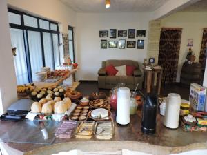 uma mesa com muitos tipos diferentes de alimentos sobre ele em Pousada Casa da Serra em São Tomé das Letras