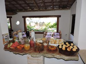 uma mesa com comida e bebidas em cima em Pousada Casa da Serra em São Tomé das Letras