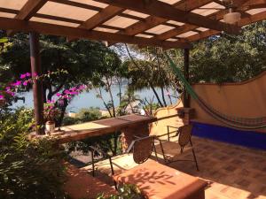 a patio with a table and chairs under a pergola at La Casa del Guamúchil in Tequesquitengo