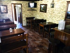 a restaurant with wooden tables and chairs and a brick wall at Casa Da Noquinhas in Bunheiro