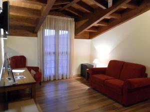 un soggiorno con divano rosso e finestra di Hotel Milagros Rio Riaza a Milagros