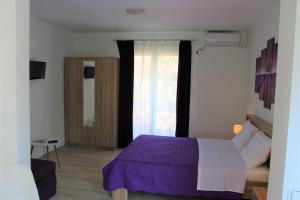 ein Schlafzimmer mit einem lila Bett und einem Fenster in der Unterkunft Apartment Tip Top in Rovinj