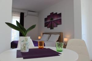 einem weißen Tisch mit zwei Gläsern und einer Pflanze darauf. in der Unterkunft Apartment Tip Top in Rovinj