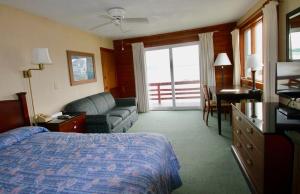 een hotelkamer met een bed en een bank bij Cape Ann Motor Inn in Gloucester