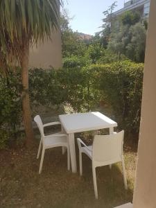 モンテジルヴァーノにあるCasa vacanza Montesilvanoの木の横の白いテーブルと椅子2脚