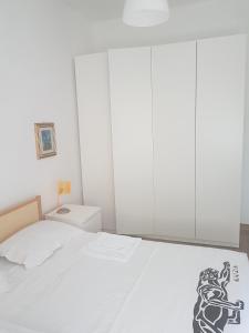 モンテジルヴァーノにあるCasa vacanza Montesilvanoの白いベッドルーム(ベッド1台、白いキャビネット付)
