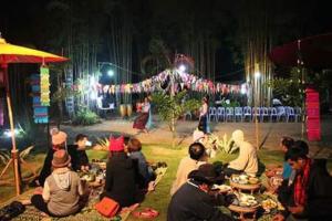 a group of people sitting at tables at a party at night at Huensala Homestay in Ban Wang Khon