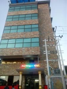 a tall building with a sign in front of it at Red Dragon Hotel in Hsipaw