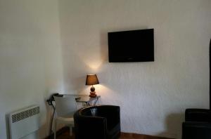 a room with a table and a television on a wall at Assam Hotel in Kenitra
