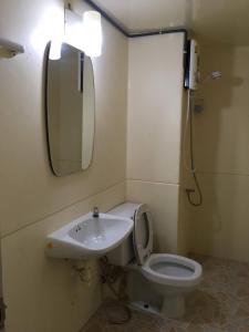 ein Badezimmer mit einem Waschbecken, einem WC und einem Spiegel in der Unterkunft Condo Muang Thong in Nonthaburi