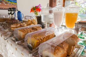 a table with sandwiches in plastic containers and drinks at Pousada Caminho Das Cachoeiras in Sao Jorge