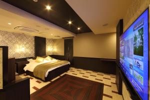 a bedroom with a bed and a flat screen tv at Hotel Water Gate Hamamatsu (Adult Only) in Hamamatsu
