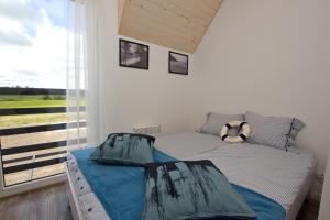 een kleine slaapkamer met een bed en een raam bij Dębki DeLuxe in Dębki