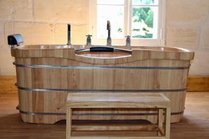 een houten bad met een wastafel in een kamer bij Domaine L'Amourette in Tizac-de-Curton