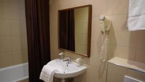 a bathroom with a sink and a mirror and a tub at Hôtel Liège Strasbourg in Paris +19 photos