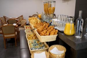 a table with baskets of pastries and orange juice at Hôtel Liège Strasbourg in Paris