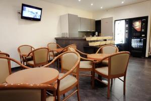 a room with chairs and tables and a kitchen at Hôtel Liège Strasbourg in Paris
