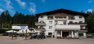 a large white building with motorcycles parked in front of it at Hotel Paradiso in Sarnonico