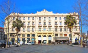 a large white building with palm trees in front of it at Luxury Homestay Le Piree in Antibes