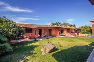 a house with a yard with a rock in front of it at Green Mountain Pousada in Florianópolis
