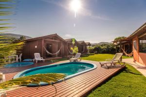a backyard with a wooden deck and a swimming pool at Green Mountain Pousada in Florianópolis