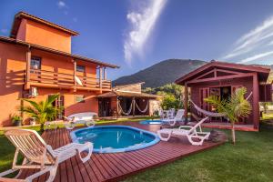 a backyard with a pool and chairs and a house at Green Mountain Pousada in Florianópolis