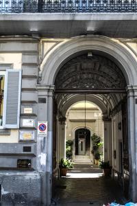 ナポリにあるGramsci Luxury Roomsのアーチ型の建物の入口