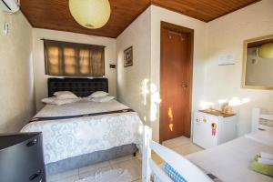 a bedroom with a bed and a table and a window at Green Mountain Pousada in Florianópolis