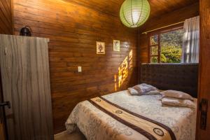 a bedroom with a bed in a wooden room at Green Mountain Pousada in Florianópolis