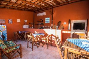 a dining room with tables and chairs and a kitchen at Green Mountain Pousada in Florianópolis