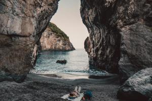 a cave on a black beach with the ocean at Villa Crawford in San Nicola Arcella