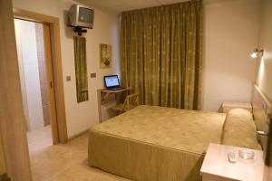 Habitación de hotel con cama y TV en Hostal Casa Paco, en Chilches