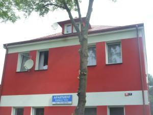 a red building with a tree in front of it at Apartment Karlovy Vary in Karlovy Vary