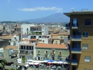 a city with buildings and a mountain in the background at B&B Casa Musumeci in Catania +24 photos
