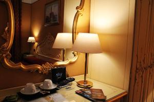 Locanda Poste Vecie في البندقية: مصباح على طاولة في غرفة الفندق
