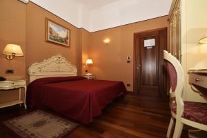 a hotel room with a red bed and a door at Locanda Poste Vecie in Venice