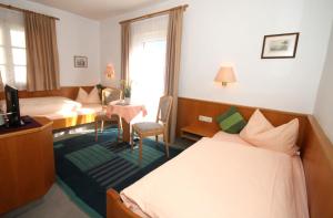 ein Hotelzimmer mit einem Bett und einem Schreibtisch in der Unterkunft Zum Franziskaner in Grainau
