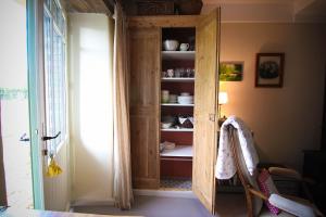 ein Raum mit einem Holzschrank mit Geschirr darin in der Unterkunft La maison d'Alcime in Plumergat + 44 Fotos