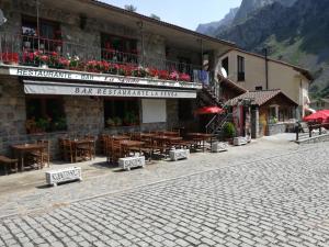 a restaurant with tables and chairs in a building at Hostal Casa Tino in Caín