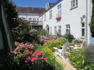 un jardín de flores frente a un edificio blanco en Foldenhus Ferieboliger og B&B en Bogense