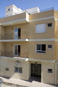 un edificio con 2 balcones en la parte superior. en Hostal Casa Paco, en Chilches