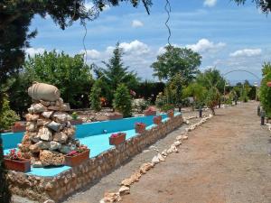 a swimming pool in a garden with a rock wall at Villa de Gor in Gor