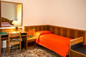 sypialnia z łóżkiem, biurkiem i lustrem w obiekcie B&B Il Colle w mieście Serra San Quirico