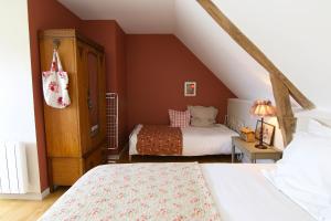 ein Schlafzimmer mit 2 Betten und ein Dachgeschoss in der Unterkunft La maison d'Alcime in Plumergat