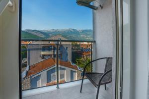a balcony with a chair and a view of a building at Apartments LORA Bokeljske brigade in Budva