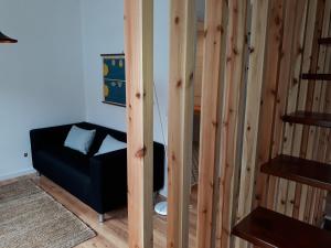 um quarto com uma cadeira preta e paredes de madeira em Casa da Sé em Angra do Heroísmo