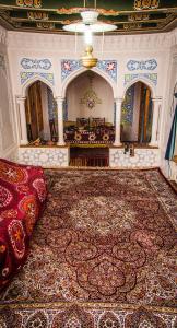 a living room with a large rug and a room with a couch at ANTICA Family Guest House in Samarkand