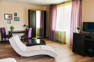a living room with a couch and a television at Green Roof Hotel in Izhevsk