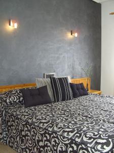 a bedroom with a black and white bed with two pillows at El Ciervo in Villaciervos