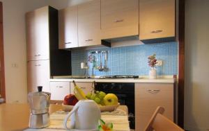 a kitchen with a bowl of fruit on a table at Casa vacanza Poesia in San Foca +11 photos